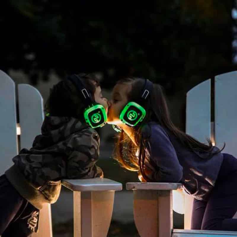 kids-silentexperience Two girls in green LED headphones hugging in the evening